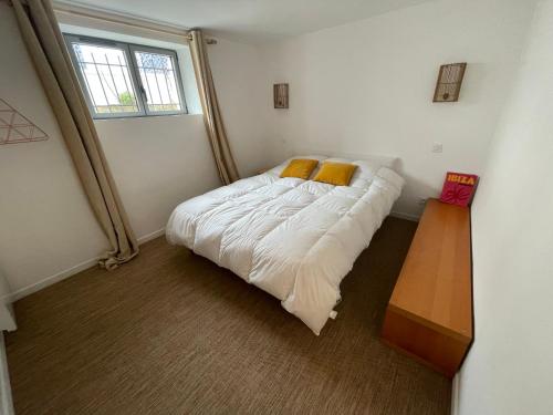 une chambre avec un grand lit avec des oreillers jaunes dans l'établissement Jolie villa en bord de mer avec wifi, à La Tranche-sur-Mer