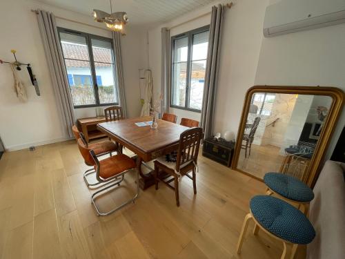 une salle à manger avec une table, des chaises et un miroir dans l'établissement Jolie villa en bord de mer avec wifi, à La Tranche-sur-Mer