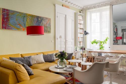 un salon avec un canapé jaune et une table dans l'établissement Veeve - Playful Atelier, à Paris
