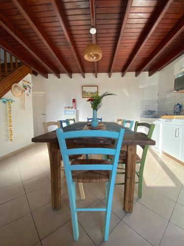une salle à manger avec une table et des chaises bleues dans l'établissement Maison familiale 8 pers, Le Marais des Mielles, à Bréhal