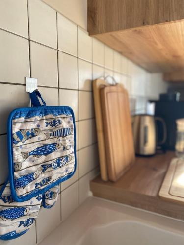 a blue and white bag hanging on a kitchen wall at Maison familiale 8 pers, Le Marais des Mielles in Bréhal