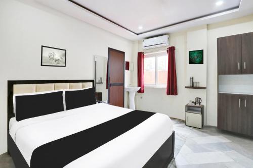 a bedroom with a black and white bed and a window at Super Hotel O MVP Double Road in Visakhapatnam