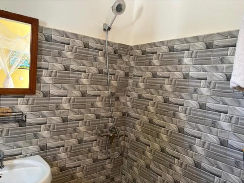 a bathroom with a sink and a shower at Hôtel Colibri Lac Rose in Niaga