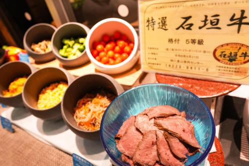 a table with bowls of different types of food at The BREAKFAST HOTEL PORTO Ishigakijima in Ishigaki Island