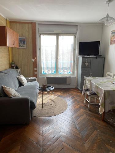 un salon avec un canapé et une table dans l'établissement Studio classé 2 étoiles avec entrée face à la mer dans immeuble Belle Époque, au Tréport