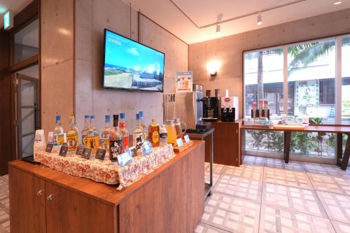 a bar with a display of bottles of alcohol at The BREAKFAST HOTEL PORTO Ishigakijima in Ishigaki Island