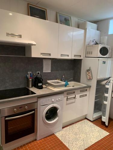 une cuisine avec des armoires blanches et une machine à laver dans l'établissement Studio classé 2 étoiles avec entrée face à la mer dans immeuble Belle Époque, au Tréport