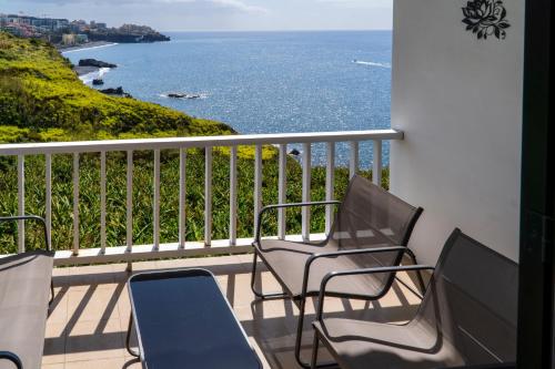 ein Balkon mit Stühlen und Blick auf das Meer in der Unterkunft Villa Irene in Funchal