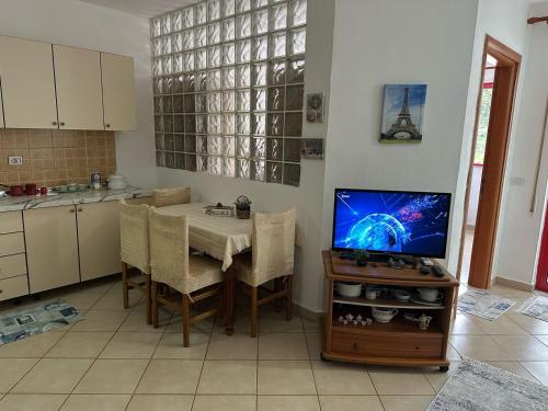 a kitchen with a table and a tv in a kitchen at Volga Cozy Apartment in Durrës