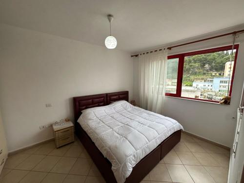 a bedroom with a bed and a window at Volga Cozy Apartment in Durrës
