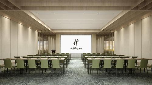 a conference room with rows of tables and chairs at Holiday Inn Quanzhou Donghai by IHG in Quanzhou