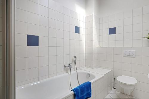 a white bathroom with a tub and a toilet at Obstbau Koch in Bodman-Ludwigshafen