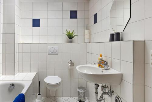 a white bathroom with a sink and a toilet at Obstbau Koch in Bodman-Ludwigshafen