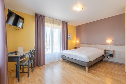 a bedroom with a bed and a desk and a television at Hôtel Restaurant Oberlé in Kilstett