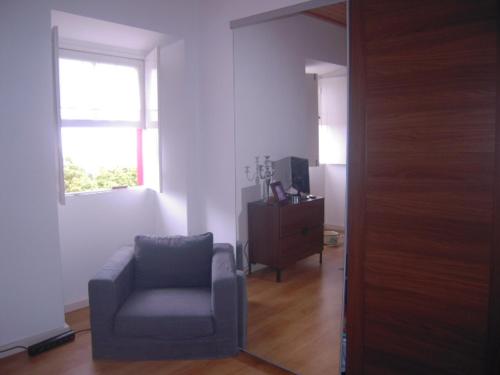 a living room with a chair and a window at Casas Alto da Bonança in São Roque do Pico