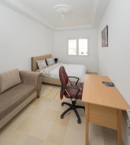 a living room with a couch and a chair and a desk at Flamingo Apartment 4 in Fouchana