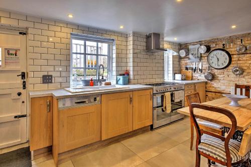 a kitchen with wooden cabinets and a sink and a table at Finest Retreats - 3 Elm Cottage in Carhampton