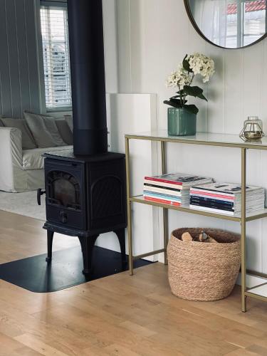 a living room with a stove and a couch at Sørlandsidyll, Risør in Søndeled
