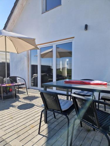 a patio with a table and chairs and an umbrella at Haus Emilia in Sierosław