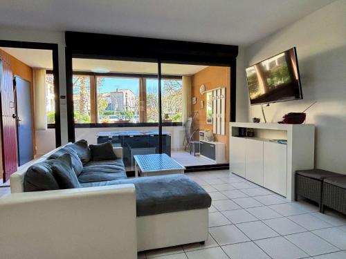 un salon avec un canapé et une télévision dans l'établissement Appartement 3 pièces- 4 personnes- ARGELES VILLAGE AR075-012, à Argelès-sur-Mer