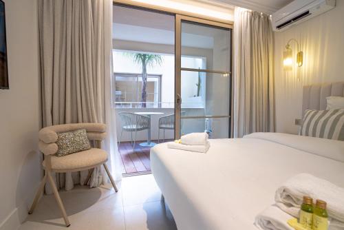 a hotel room with two beds and a chair at Maison Raphaël studios - Plages, Ville et Gare à Pied in Saint-Raphaël