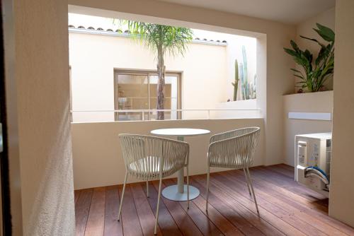 a dining room with a table and two chairs at Maison Raphaël studios - Plages, Ville et Gare à Pied in Saint-Raphaël