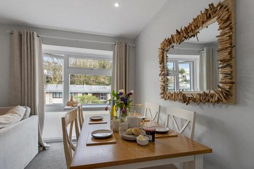Un comedor con una mesa y un espejo. en The Snug - Brixham, en Brixham