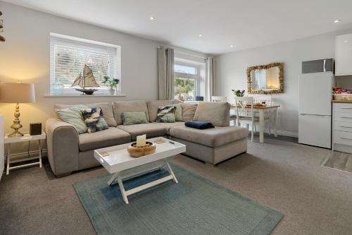 a living room with a couch and a table at The Snug - Brixham in Brixham