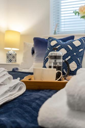 a tray with a coffee maker on a bed at The Snug - Brixham in Brixham