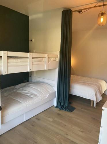 Ce dortoir comprend 2 lits superposés et des rideaux verts. dans l'établissement Saint Jorioz, Cozy appartement tout près du lac, à Saint-Jorioz