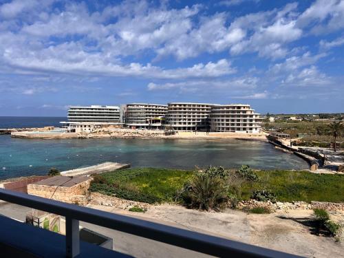 a view of a hotel with the ocean and buildings at Riviera Spa Resort - Adults Only in Mellieħa