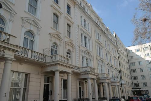 un gran edificio blanco con columnas y ventanas en Paddington Apartments, en Londres