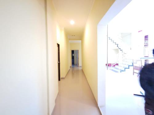 a hallway in a building with a stair case at Hotel O Majest in Nyerakat