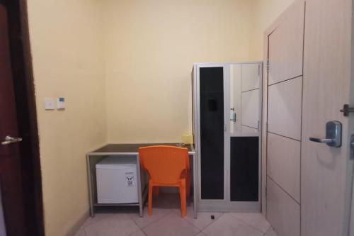 a room with a desk and a orange chair at Hotel O Majest in Nyerakat