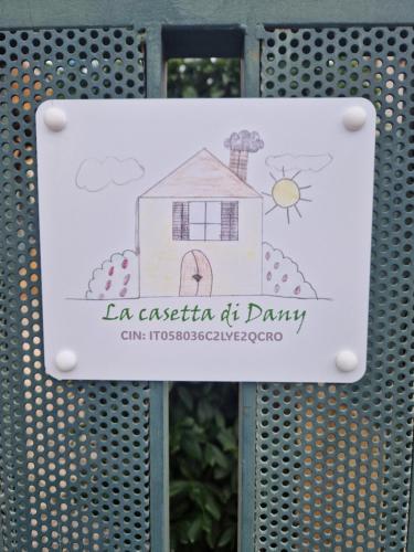 a sign on a metal gate with a house at La casetta di Dany in Fiano Romano