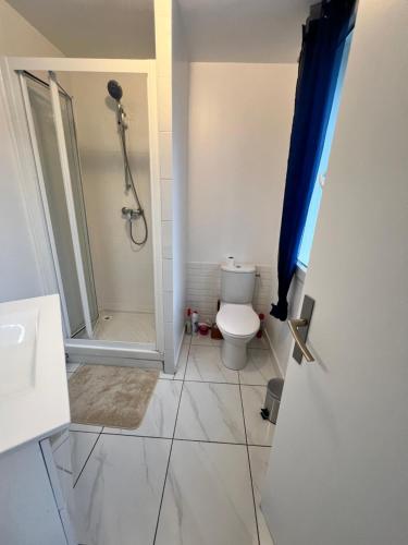 La salle de bains est pourvue de toilettes et d'une douche. dans l'établissement NEW 2 bedroom House 15mins from Paris by Train, à Sarcelles