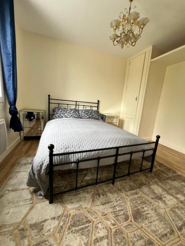 - une chambre avec un lit dans une pièce dotée d'un lustre dans l'établissement NEW 2 bedroom House 15mins from Paris by Train, à Sarcelles