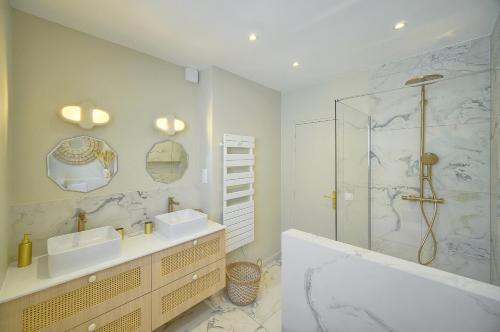 une salle de bain avec deux lavabos et une douche dans l'établissement somptueux 4 pieces vue mer et parking A3B132, à Cannes