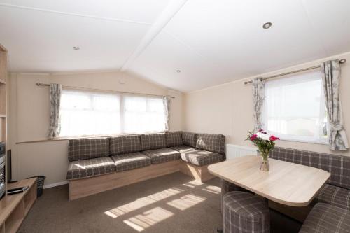 a living room with a couch and a table at Tencreek Holiday Park in Looe