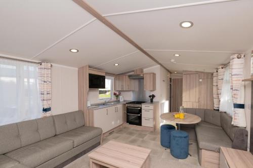 a living room with a couch and a table at Tencreek Holiday Park in Looe