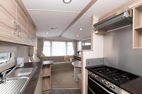 a kitchen with a sink and a stove at Tencreek Holiday Park in Looe