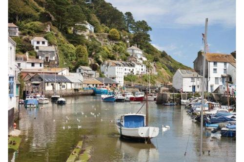 a group of boats docked in a harbor with houses at Tencreek Holiday Park in Looe