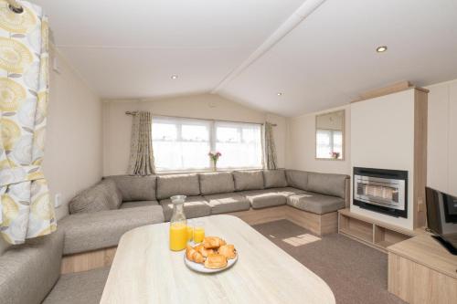 a living room with a couch and a table at Tencreek Holiday Park in Looe