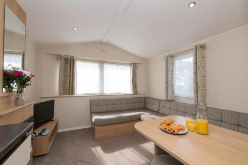 a living room with a couch and a table at Tencreek Holiday Park in Looe