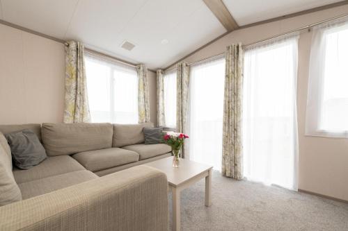 a living room with a couch and a table at Tencreek Holiday Park in Looe