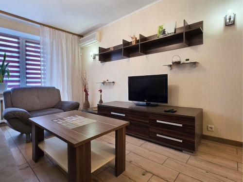 a living room with a television and a table and a chair at Home Hotel Apartments on Kontraktova Ploshcha in Kyiv