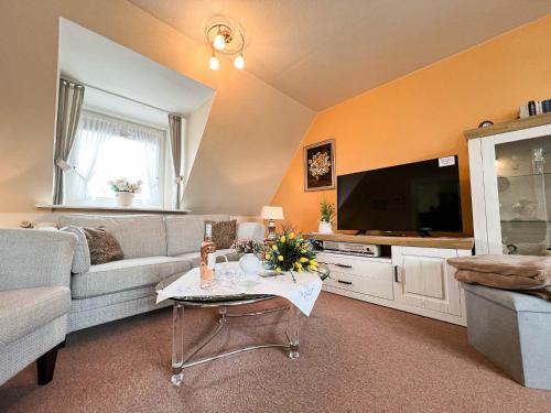 a living room with a couch and a tv at Solbeck im Käpitänshaus Andresen in Westerland (Sylt)