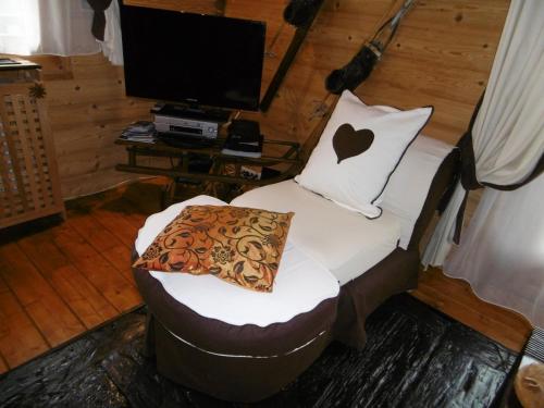 Cette chambre dispose d'une chaise avec un oreiller et d'une télévision. dans l'établissement Charmant T3 à Châtel avec balcon, proche centre et remontées mécaniques, 6 personnes - FR-1-676-10, à Châtel
