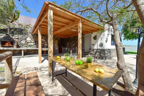 einem Holztisch vor einem Haus mit einem Kamin in der Unterkunft Finca Aguatona RC10 by VillaGranCanaria in Ingenio