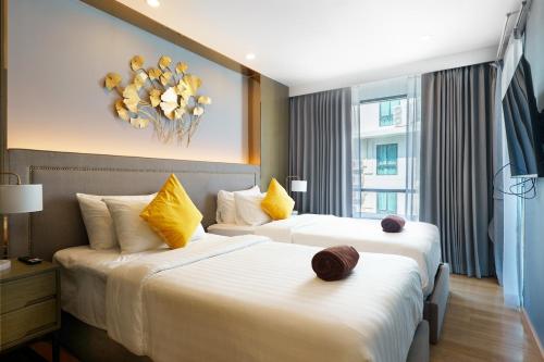 a hotel room with two beds with yellow pillows at View 2Bdr Lux Life Rawai in Rawai Beach